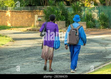 Alberton, Südafrika - unidentifiziertes schwarzes afrikanisches Paar mittleren Alters isoliert auf einer öffentlichen Straße in einem Bild eines Wohnvororts in horizontalem Format Stockfoto