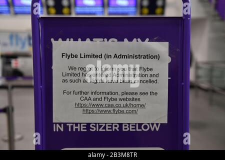 Ein Hinweis der leeren Flybe Check-In-Schalter am Birmingham International Airport, wie Flybe, Europas größte regionale Fluggesellschaft, in die Verwaltung eingebrochen ist. Stockfoto