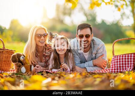 Glückliche Familie, die ein Picknick in der Natur macht.Lächelnde Familie, die im Park picknickt.Sommerzeit. Stockfoto