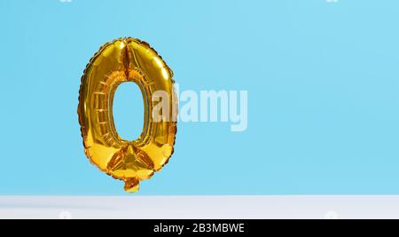 Golden Foil Ballon in Form von Zahlen auf blauem Hintergrund. Levitationseffekt Stockfoto