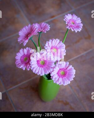 Wunderschönes Rosafarben-Blumenstrauß in grüner Vase. Draufsicht. Stockfoto