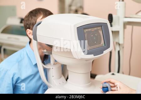 Augenarzt im Untersuchungsoptikerlabor mit männlichem Patienten. Männer Auge Stockfoto