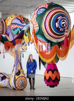 Die Galerie-Mitarbeiterin Rachel Jarvis sieht ein Werk mit dem Titel Valkyrie Marina Rinaldi, 2014, von der Künstlerin Joana Vasconcelos, das Teil ihrer größten britischen Ausstellung bis heute, Jenseits, im Yorkshire Sculpture Park ist. Stockfoto