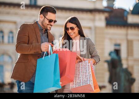 Porträt eines fröhlichen Paares mit Einkaufstaschen.Schönes junges Liebespaar mit Einkaufstaschen.Menschen,Shopping und Konsumkonzept. Stockfoto