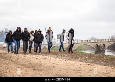 Edirne, Türkei. März 2020. Syrische Flüchtlinge wandern entlang des Flusses "Tunca Nehri" nahe dem Grenzübergang Pazarkule-Kastanies in der türkischen Grenzstadt Edirne. Kredit: Mohssen Assanimoghaddam / dpa / Alamy Live News Stockfoto