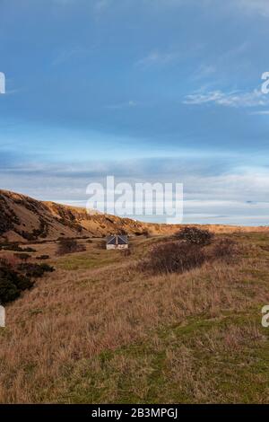 Ein verlassenes Cottage- und Eishaus Der Fischer, das sich vom Strand in St. Cyrus unterhalb der Vulkanklippen befindet. Stockfoto