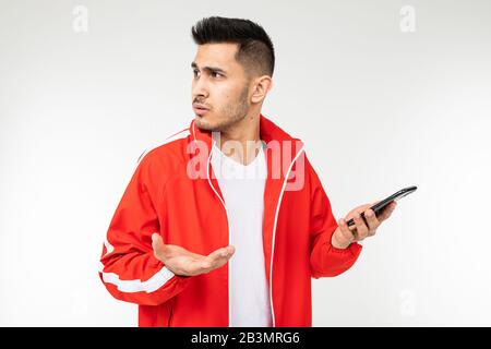 Mann in Sportswear in roten Telefongesprächen auf weißem Hintergrund Stockfoto