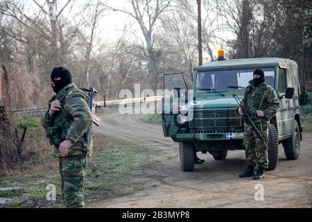 Kastanies, Evros, Griechenland - 1. März 2020: Griechische Soldaten bewachen, während sich in der Nähe des Grenztores Kastanies an der griechisch-türkischen Grenze Migranten sammeln Stockfoto