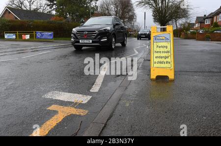 Das Parken hier könnte die Lebenszeichen eines Kindes außerhalb der Hilltop First School Windsor gefährden. Auf den Zickzacklinien sind Schilder angebracht, um das Parken zu verhindern. Stockfoto