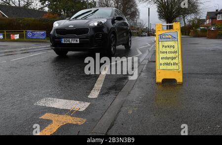 Das Parken hier könnte die Lebenszeichen eines Kindes außerhalb der Hilltop First School Windsor gefährden. Auf den Zickzacklinien sind Schilder angebracht, um das Parken zu verhindern. Stockfoto