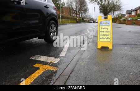 Das Parken hier könnte die Lebenszeichen eines Kindes außerhalb der Hilltop First School Windsor gefährden. Auf den Zickzacklinien sind Schilder angebracht, um das Parken zu verhindern. Stockfoto