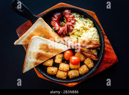 Amerikanisches Frühstück auf einem Holzteller. Stockfoto