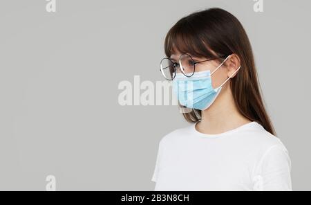 Asian Woman fühlt sich unwohl und trägt Gesichtsschutzmaske auf grauem Studiohintergrund. Platz für Text kopieren. Die erste Verteidigung gegen die Epidemie von Stockfoto