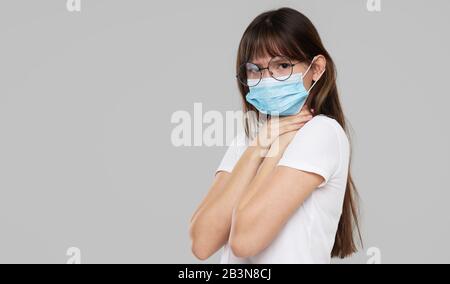 Asian Woman fühlt sich unwohl und trägt Gesichtsschutzmaske auf grauem Studiohintergrund. Platz für Text kopieren. Die erste Verteidigung gegen die Epidemie von Stockfoto