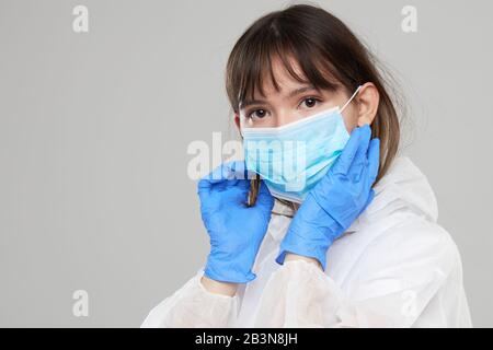 Asian Woman legt eine Schutzmaske und einen Anzug an. Schutz vor Grippe, ebola, Tuberkulose und Virus. Persönliche Schutzausrüstung gegen biologische Ha Stockfoto