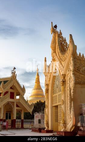 Maha Wizaya Pagode in der Dämmerung, mit dem leuchtenden Goldchedi (Stupa) der Shwedagon Pagode im Hintergrund, Yangon (Rangun), Myanmar (Birma), Asien Stockfoto