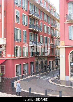 Markante hohe Gebäude mit einem roten façade im Mittelmeer an der Ecke von Place Massena & Rue Alexandre Mari im Zentrum von Nizza, der französischen Riviera. Stockfoto