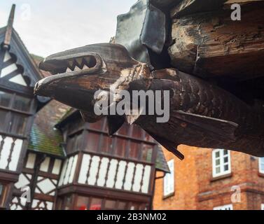 Der Mardol Dragon, ein geschnitzter Holzdrache, hängt auf dem Kopf an einem Gebäude im historischen Shrewsbury, Shropshire, England Stockfoto