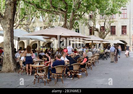 Straßencafés und Touristen auf dem Place aux Herbes Town Square Uzes oder Uzès Gard France Stockfoto