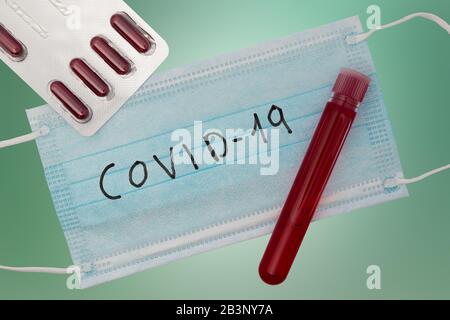 Bluttestkonzept Coronavirus. Draufsicht mit Pillen, Reagenzglas mit Patientenblut und Atemmaske. Ausbruch des chinesischen Wuhan-Virus. 2019-nCoV (COVID Stockfoto