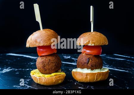 Hausgemachte mediterrane Mini Falafel Vegan Burger mit Tzatziki und Turmeric Sauce. Starteressen mit Holzstäbchen. Gesunde Organische Lebensmittel. Stockfoto