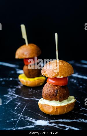 Hausgemachte mediterrane Mini Falafel Vegan Burger mit Tzatziki und Turmeric Sauce. Starteressen mit Holzstäbchen. Gesunde Organische Lebensmittel. Stockfoto