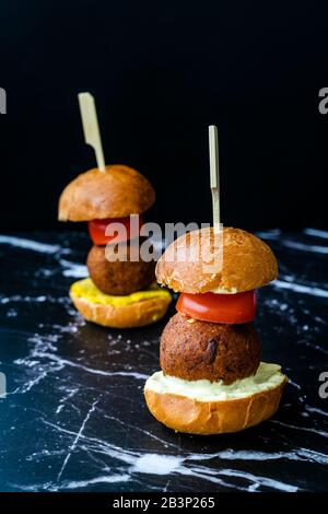 Hausgemachte mediterrane Mini Falafel Vegan Burger mit Tzatziki und Turmeric Sauce. Starteressen mit Holzstäbchen. Gesunde Organische Lebensmittel. Stockfoto