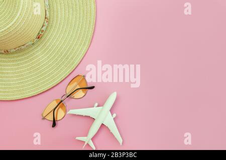 Strandzusammensetzung im Sommer. Minimale, einfache flache Lage mit planaren Sonnenbrillen und Hut isoliert auf pastellrosa Hintergrund. Urlaub Reise Abenteuer Konzept. Kopierbereich in der Draufsicht Stockfoto