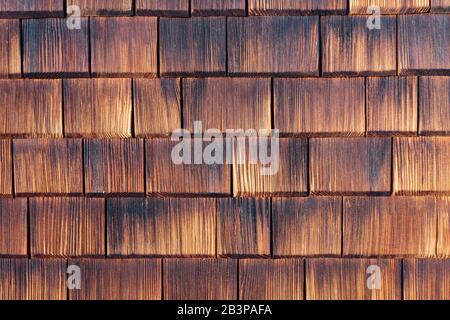 Fassade mit Holzschindeln verkleidet. Stockfoto