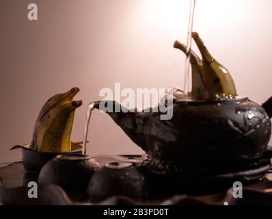 Zwei Delfine formten Bananen, die im Teakup spielen Stockfoto