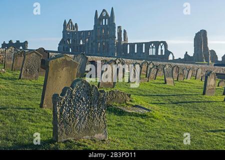 Überreste einer antiken englischen Abteiruine mit gotischer Architektur in ländlicher Landschaft und in Friedhöfen Stockfoto