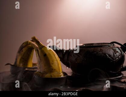 Zwei Delfine formten Bananen, die im Teakup spielen Stockfoto