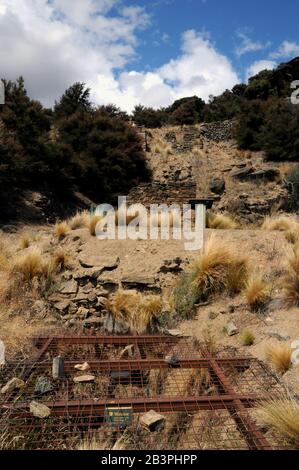 Ein Stahl- und Drahtgitter blockiert einen Minenschacht im alten Goldbergbaugebiet im Bendigo Historic Reserve, Central Otago, Neuseeland. Stockfoto