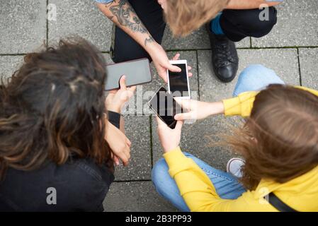 Eine hochwinkelige Ansicht von Freunden mit Handy Stockfoto