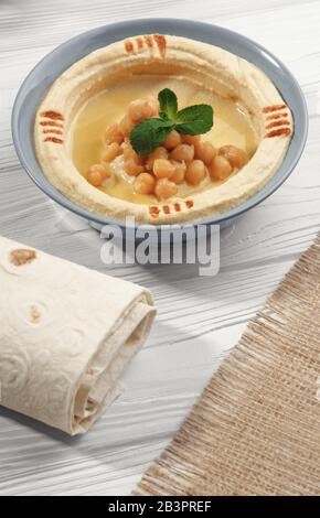 Draufsicht über arabischen Hummus und gewickeltes Brot und hessischen Sack auf dem Tisch Stockfoto