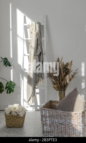 Vertikaler Schuss aus Rattan-Körben und -Pflanzen mit Decke auf Holzleiter Stockfoto