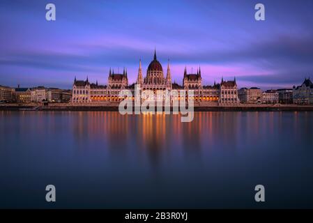 Ungarische Parlamentsgebäude in Budapest bei Sonnenuntergang mit Donau-Fluss Stockfoto