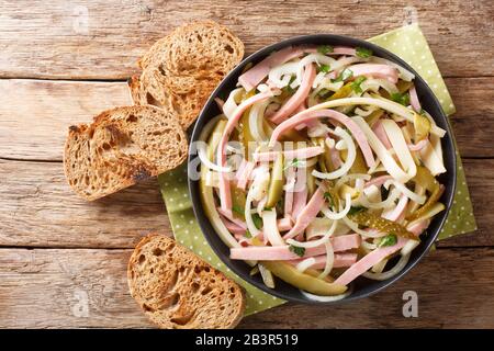 Servieren von Schweizer Wurstsalat in einem Teller auf dem Tisch horizontale Draufsicht von oben Stockfoto