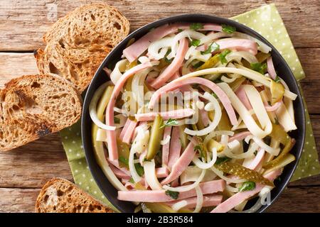 Traditioneller Wurstsalat Schweizer Wurstsalat würzt mit würziger Sauce Nahaufnahme in einem Teller auf dem Tisch horizontale Draufsicht von oben Stockfoto