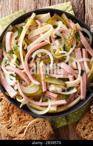 Hausgemachter frischer Schweizer Wurstsalat in einer Platte auf dem Tisch vertikale Draufsicht von oben Stockfoto