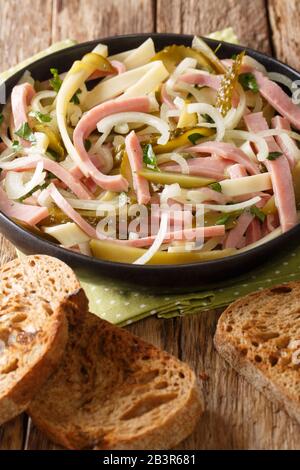 Schweizer Wurstsalat beliebt in Deutschland, Autria und der Schweiz in einem Teller auf dem Tisch. Vertikal Stockfoto