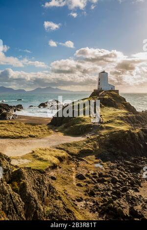 TWR Mawr Leuchtturm auf der Insel Llanddwyn, mit Snowdonia im Hintergrund, Anglesey Stockfoto