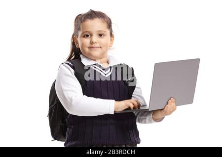 Schulmädchen in einer Uniform, die einen Laptop-Computer hält und sich isoliert auf weißem Hintergrund aufstellt Stockfoto