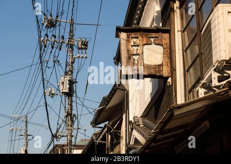 Blick auf die Straße mit Stromleitungen und Holzbalken auf der Miyajima-Insel, direkt vor Hiroshima, Japan Stockfoto