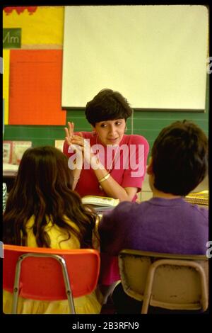 Austin Texas USA, um 1988: Grundschullehrerin spricht mit Schülern im Klassenzimmer. ©Bob Daemmrich Stockfoto