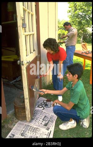 Austin Texas USA, 1988: Hispanische Familie, die an einem Schuppen in ihrem Hinterhof Wartung macht. MR RR-0101 ©Bob Daemmrich Stockfoto