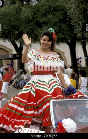 San Antonio, Texas USA: Teenager, die ein Kostüm in mexikanischen Flaggen tragen, winken während der Parade zum Diez y Seis Festival in einem Cabrio zu den Zuschauern. ©Bob Daemmrich Stockfoto