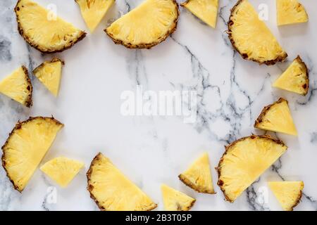 Ananas auf weißem Marmorhintergrund mit einem Kopierraum in der Mitte Stockfoto
