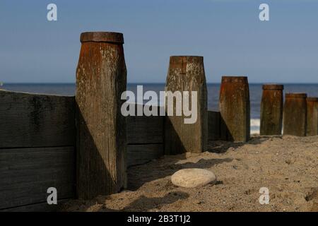 Meeresschutz, Groynes werfen einen Schatten auf einen Strand. Stockfoto