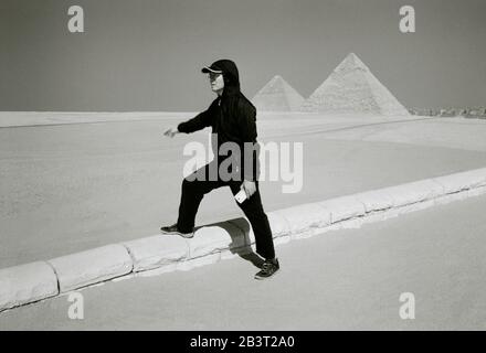 Reise-Fotografie in Schwarz und Weiß - Touristen an der Pyramide von Khafre und der Großen Pyramide an den Pyramiden von Gizeh in Kairo in Ägypten in Nordafrika Stockfoto